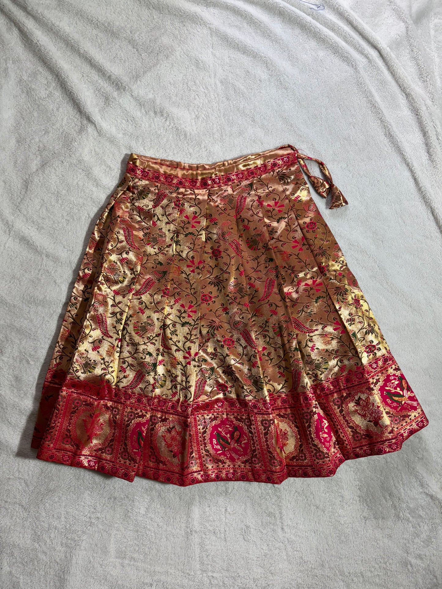 Rani pink blouse with handmade aari work and golden colour lehenga with floral design all over pattu pavadai