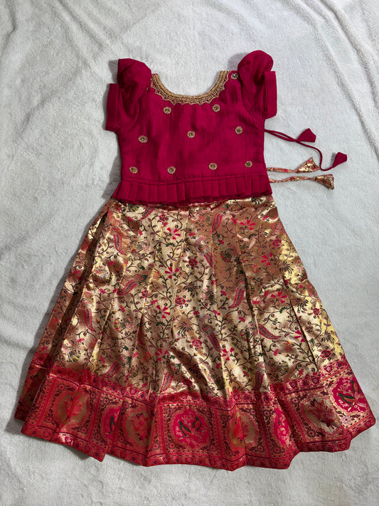 Rani pink blouse with handmade aari work and golden colour lehenga with floral design all over pattu pavadai