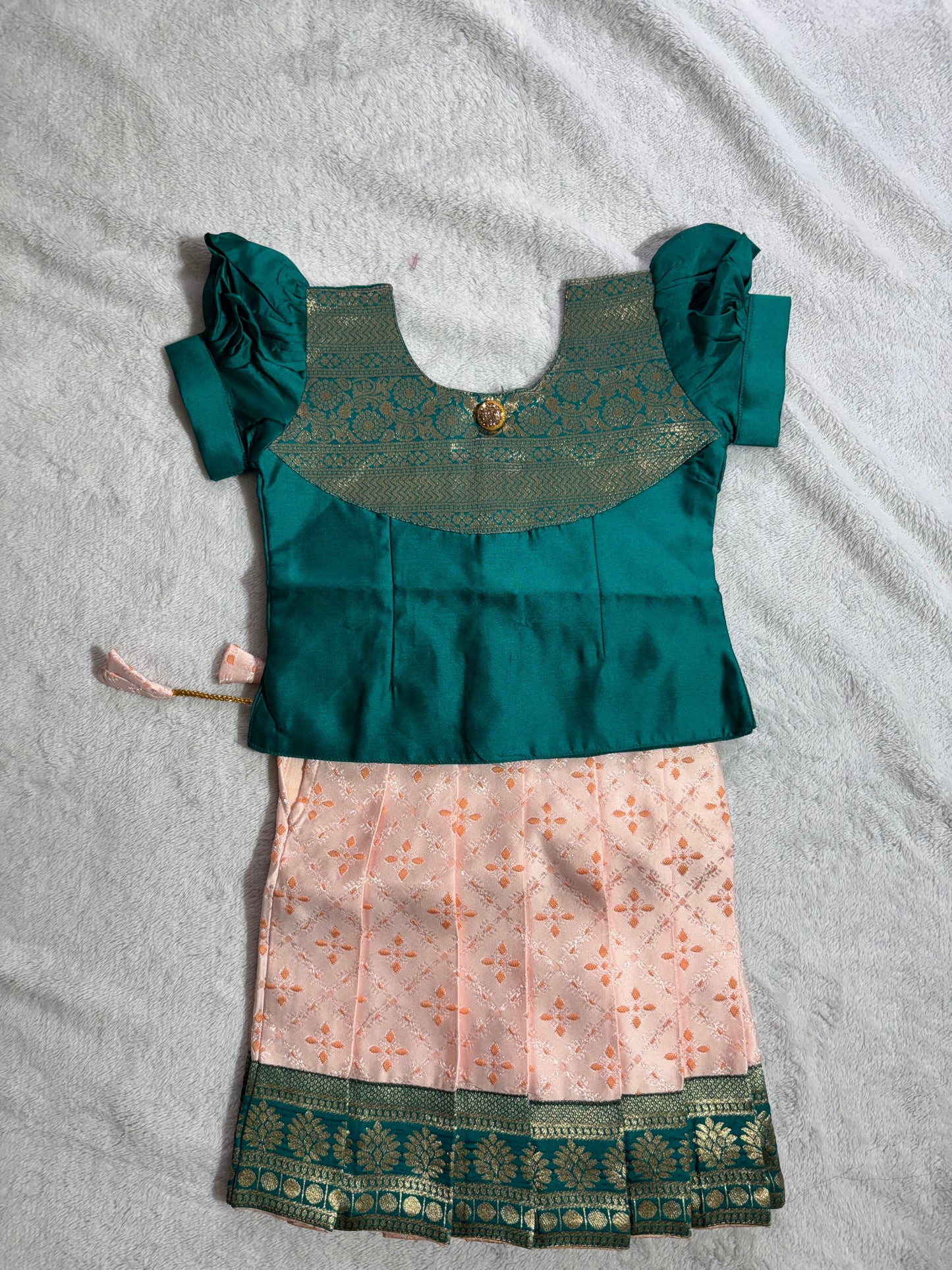 Dark green blouse with light peach lehenga pattu pavadai