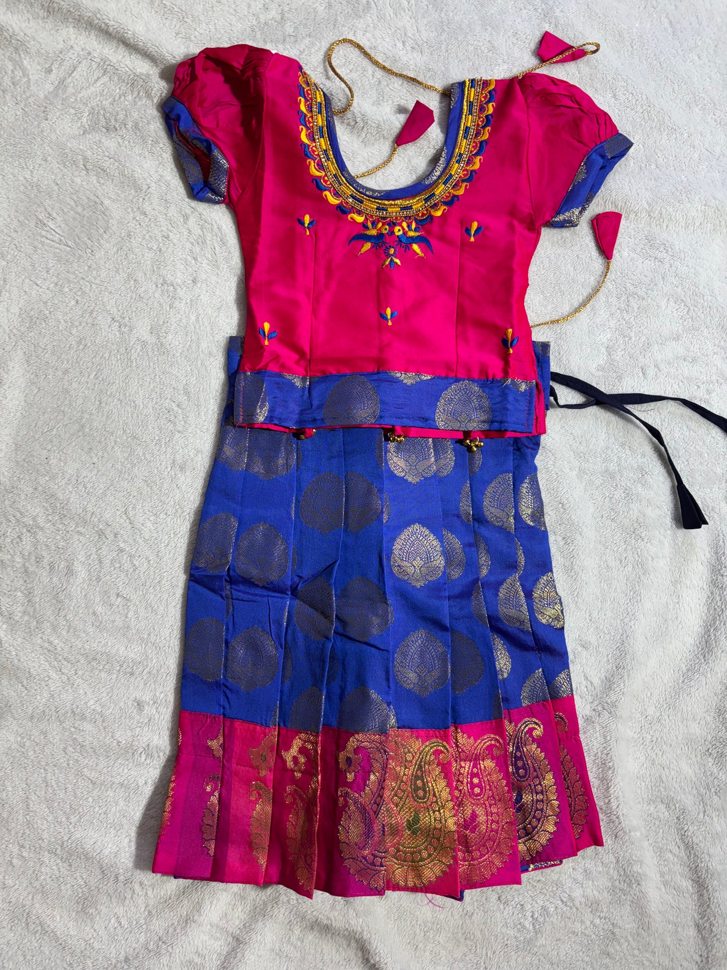 Pattu Pavade vibrant pink blouse embroidery around the neckline, rich blue lehenga.