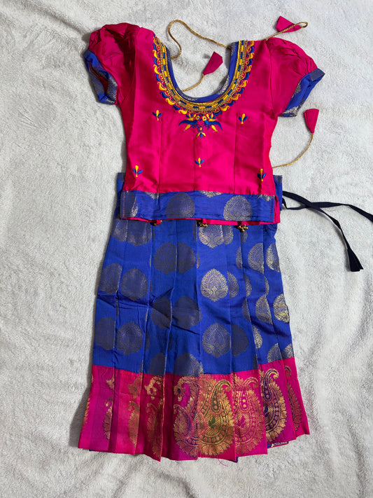 Pattu Pavade vibrant pink blouse embroidery around the neckline, rich blue lehenga.
